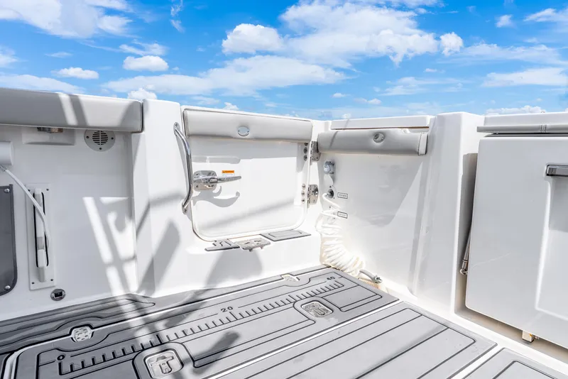 Slide: The Image of 2024 Pursuit S 358 Sport boat deck with storage and seating under a blue sky. - 35