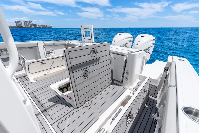 Slide: The Image of 2024 Pursuit S 358 Sport boat with open deck hatch, twin Yamaha engines, and ocean backdrop. - 39