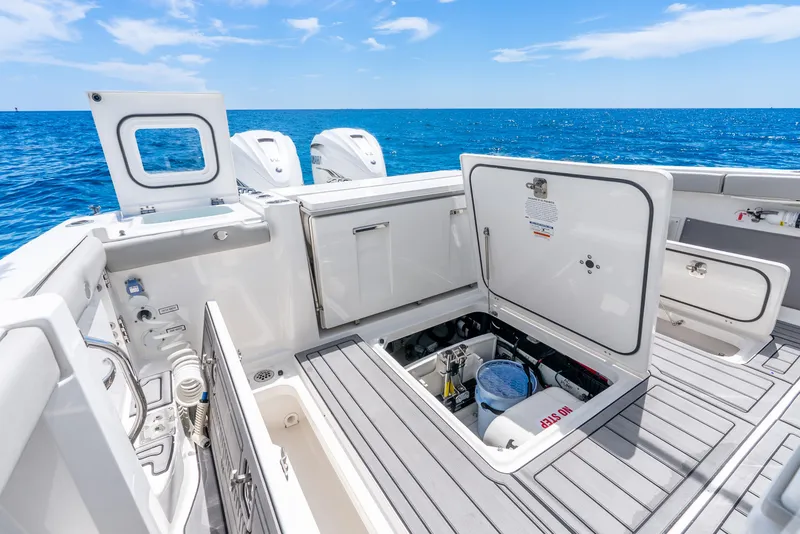 Slide: The Image of 2024 Pursuit S 358 Sport boat deck with open storage compartments, ocean view. - 40
