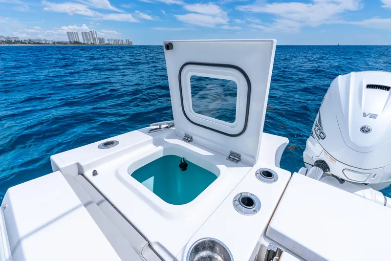 Slide: The Image of 2024 Pursuit S 358 Sport boat with open hatch and V8 engine on blue ocean. - 43