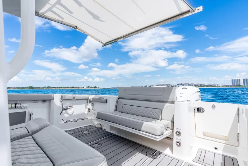 Slide: The Image of 2024 Pursuit S 358 Sport boat interior with luxurious seating and ocean view. - 47