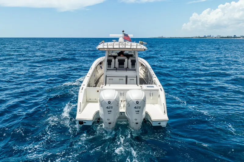 Slide: The Image of 2024 Pursuit S 358 Sport boat cruising on open ocean with twin engines. - 7