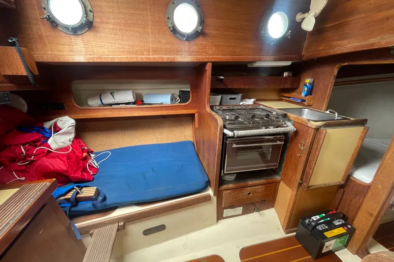 Slide: The Image of Interior of a 1980 Falmouth Cutter sailboat with cozy cabin and kitchen area. - 15