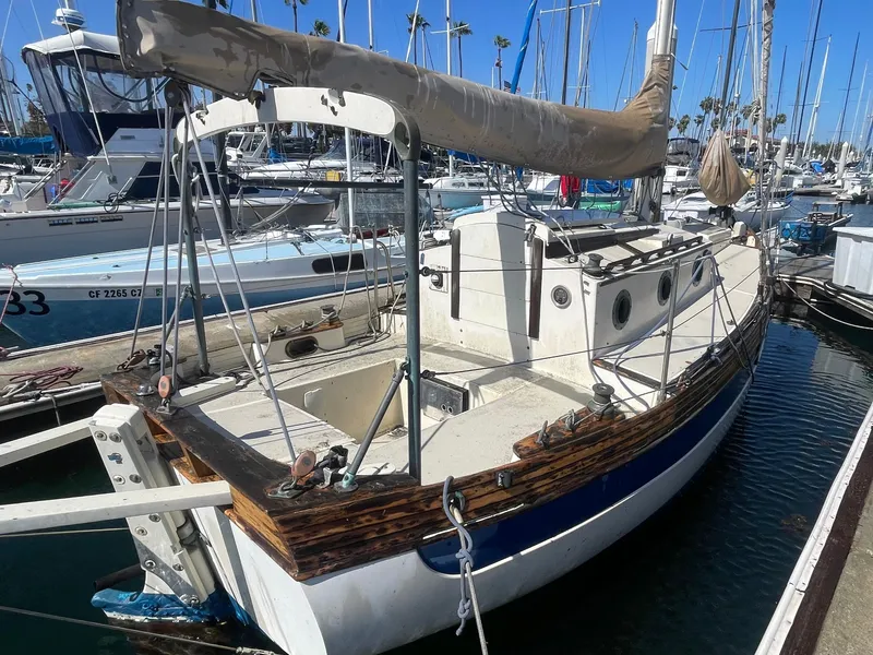 Slide: The Image of Falmouth sloop sailboat from 2000 docked in a marina, surrounded by other boats. - 4
