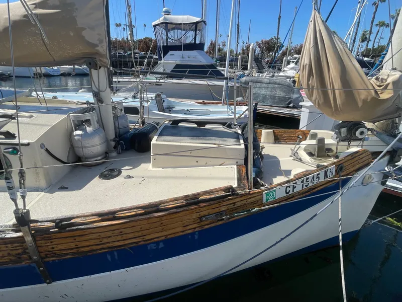 Slide: The Image of Falmouth sloop sailboat from 2000 docked in marina, featuring wooden trim and equipment. - 5