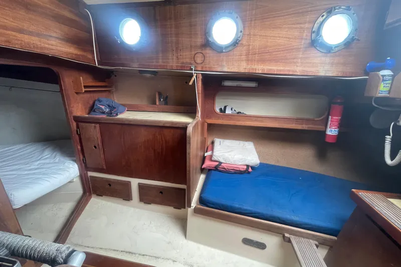 Slide: The Image of Interior of 1980 Falmouth Cutter sailboat with wooden cabinetry and sleeping berths. - 8