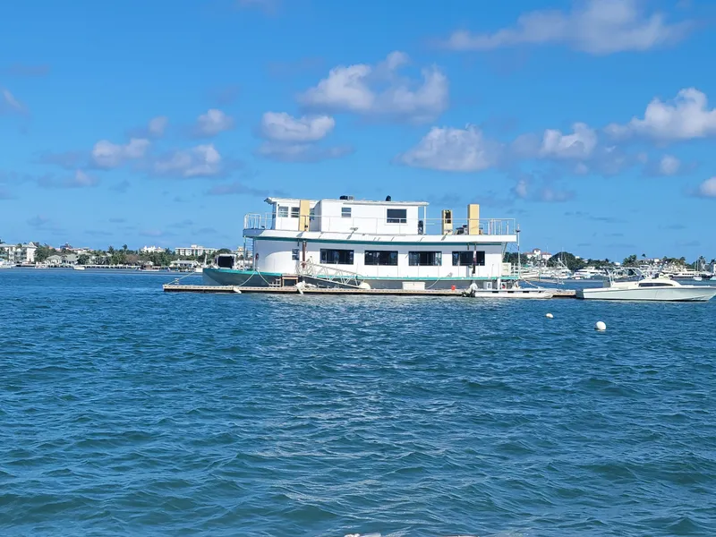 Slide: The Image of Custom 2003 floating home on water, clear blue sky, coastal background. - 20