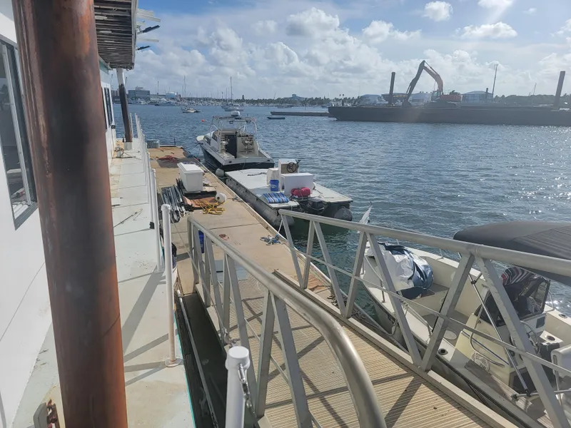 Slide: The Image of Floating home docked by the water with boats and industrial background, sunny day. - 26