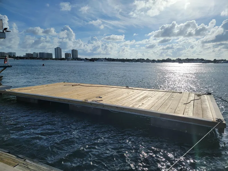 Slide: The Image of Floating wooden platform on water, sunny day, city skyline in background. - 41