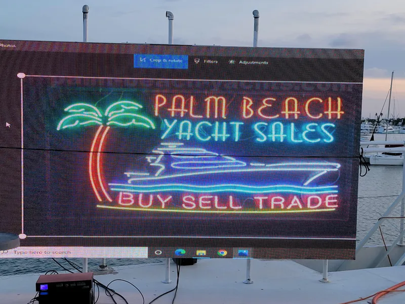 Slide: The Image of Neon sign for Palm Beach Yacht Sales with palm tree and yacht graphic. - 6