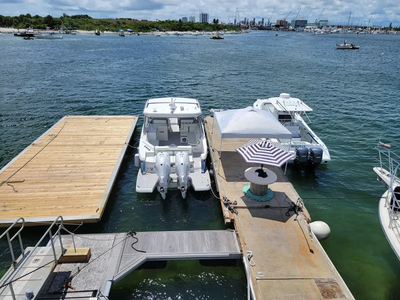 Slide: The Image of Floating home docked with boats, featuring a striped umbrella, on a sunny waterfront. - 7