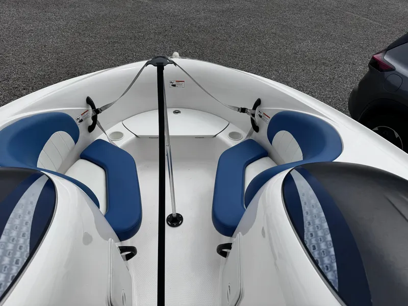 Slide: The Image of 2003 Yamaha Boats 210LX interior with blue and white seating, parked on gravel. - 10