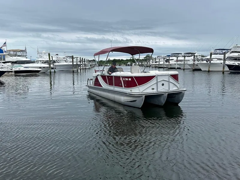 Slide: The Image of 2017 South Bay 500RS pontoon boat docked in a marina with other boats. - 6