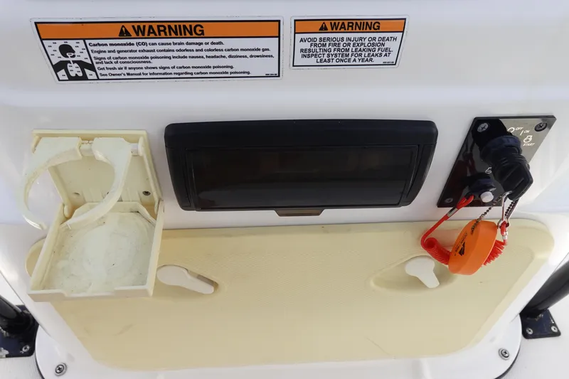 Slide: The Image of Control panel of 2022 Key Largo 1800 Center Console with warning labels and ignition switch. - 17