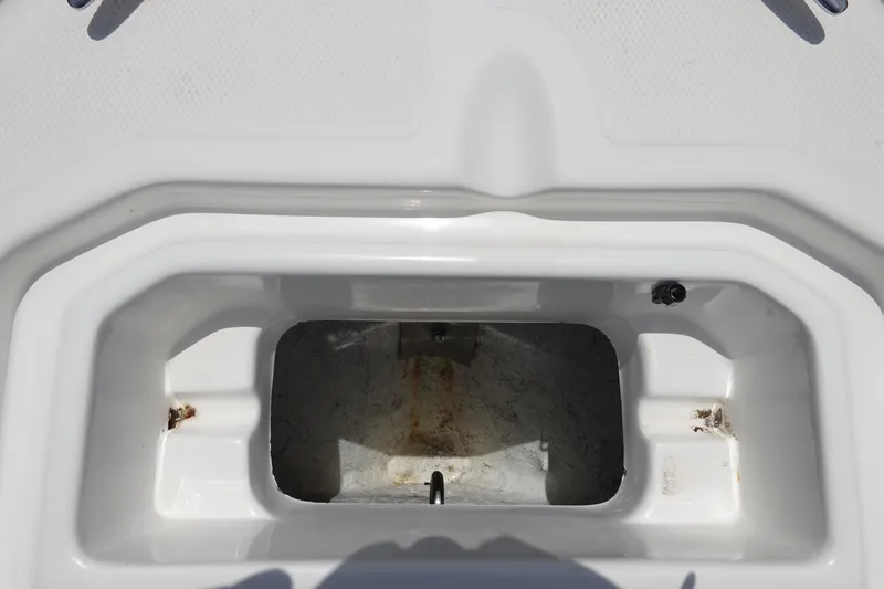 Slide: The Image of Key Largo 1800 Center Console 2022 boat storage compartment, white interior, open lid. - 26