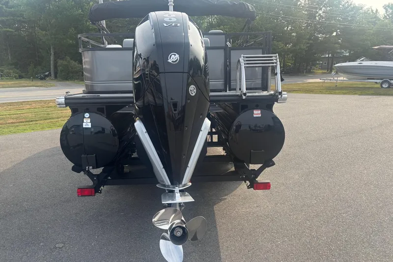 Slide: The Image of 2025 Regency 250 DL3 pontoon boat with powerful outboard motor, parked on pavement. - 3