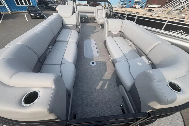 Slide: The Image of 2025 Regency 250 DL3 pontoon boat interior with spacious gray seating and cup holders. - 4
