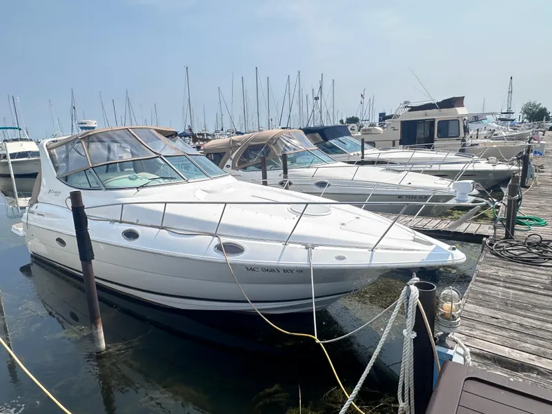 The Image of 1998 Cruisers Yachts 3075 Rogue docked at marina, surrounded by other boats. - 0