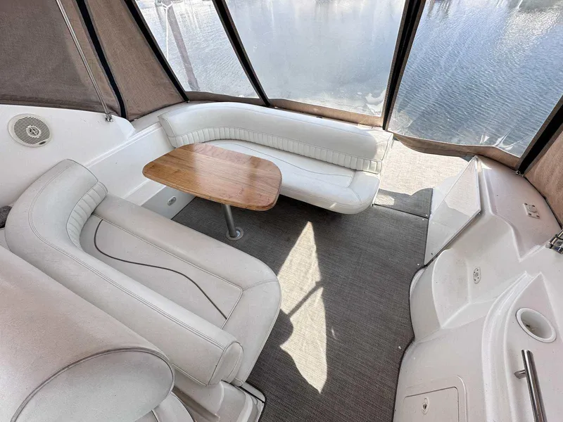 Slide: The Image of 1998 Cruisers Yachts 3075 Rogue interior with white seating and wooden table. - 2