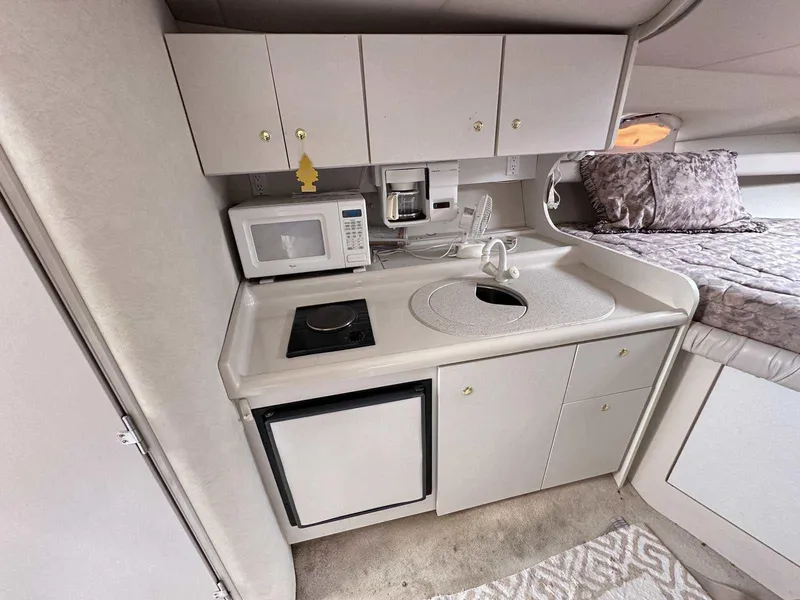 Slide: The Image of 1998 Cruisers Yachts 3075 Rogue interior kitchen with microwave, stove, and sink. - 15