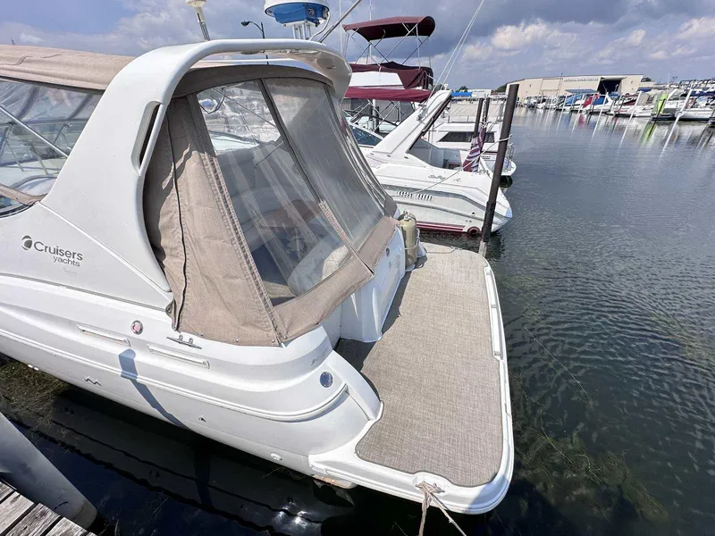 Slide: The Image of 1998 Cruisers Yachts 3075 Rogue docked at marina, rear view with canopy. - 3