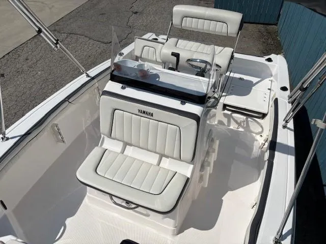 Slide: The Image of 2017 Yamaha Boats 190 FSH Deluxe interior with white seating and steering console. - 13