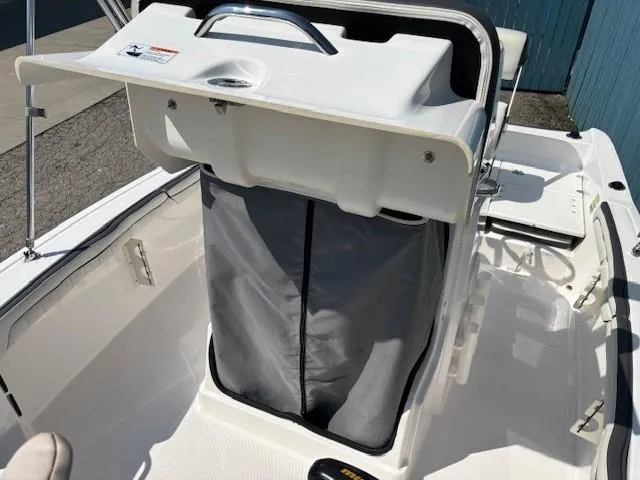 Slide: The Image of 2017 Yamaha Boats 190 FSH Deluxe center console with storage compartment, open lid view. - 15