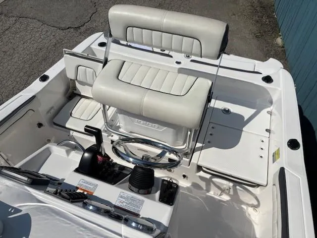 Slide: The Image of 2017 Yamaha Boats 190 FSH Deluxe interior with white seating and steering console. - 17