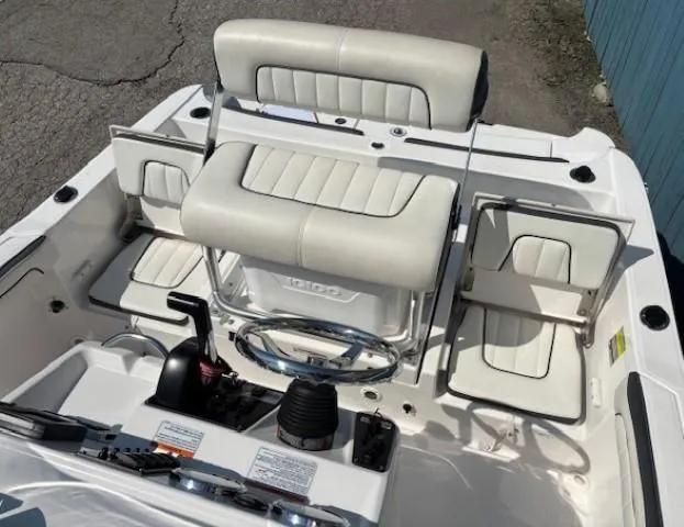 Slide: The Image of 2017 Yamaha Boats 190 FSH Deluxe interior with white seating and control panel. - 18
