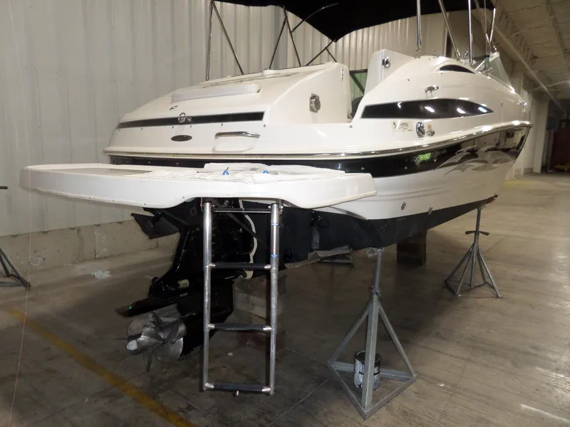 Slide: The Image of 2006 Maxum 2400 SR3 boat on stands in indoor storage facility. - 2