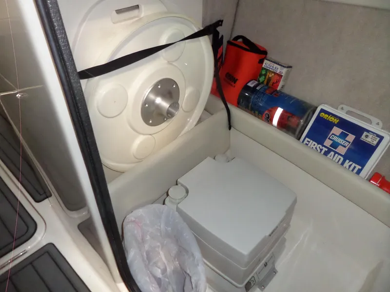 Slide: The Image of Storage compartment in a 2006 Maxum 2400 SR3 boat with safety equipment and supplies. - 30
