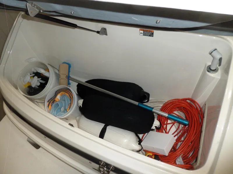 Slide: The Image of Storage compartment of 2006 Maxum 2400 SR3 boat with cleaning supplies and equipment. - 40