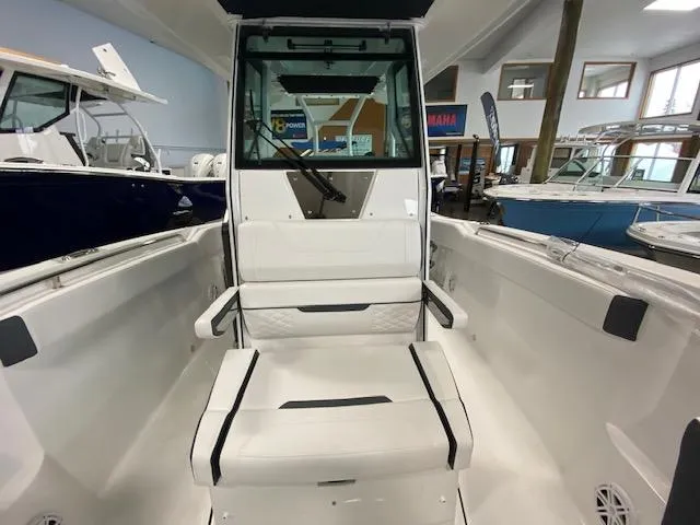 Slide: The Image of 2022 Blackfin 272 CC boat interior with seating and console in showroom. - 10