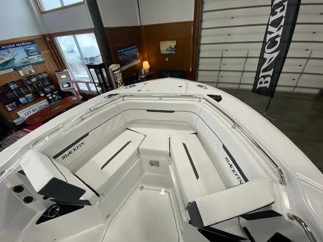 Slide: The Image of 2022 Blackfin 272 CC boat interior with white seating in showroom. - 12