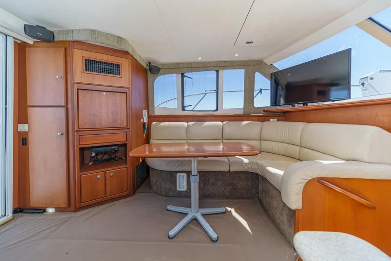 Slide: The Image of Luxurious interior of 2004 Silverton 38 Convertible yacht with plush seating and wooden cabinetry. - 13