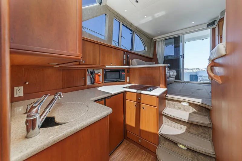 Slide: The Image of 2004 Silverton 38 Convertible yacht interior with modern kitchen and cozy seating area. - 15