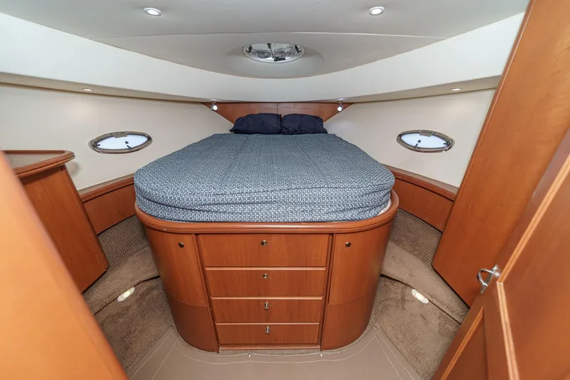 Slide: The Image of 2004 Silverton 38 Convertible yacht bedroom with wood cabinetry and round bed. - 16
