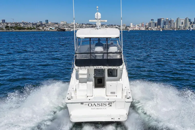 Slide: The Image of 2004 Silverton 38 Convertible yacht cruising in San Diego waters, city skyline in background. - 3