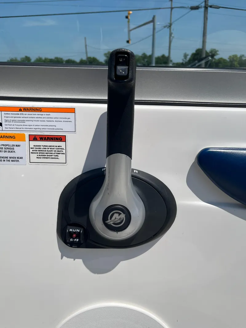 Slide: The Image of Throttle control of 2013 Rinker Captiva 186 BR FS OB boat with warning labels. - 16