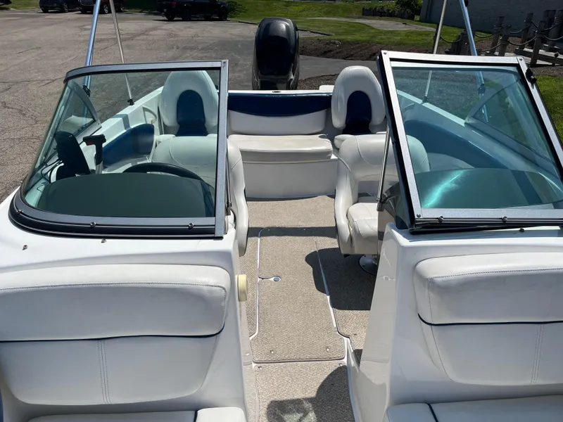 Slide: The Image of 2013 Rinker Captiva 186 BR FS OB boat interior with white seating and windshield. - 5