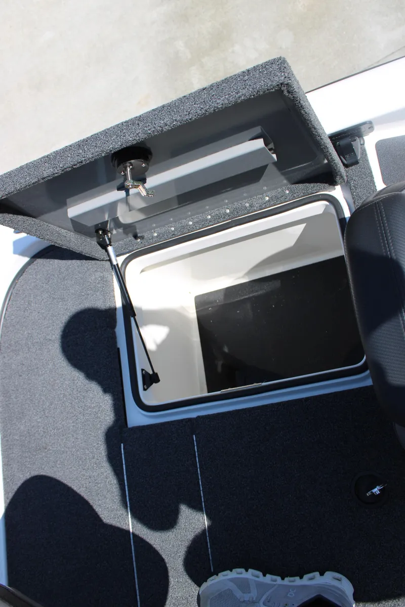 Slide: The Image of 2022 Caymas CX 18 SS boat storage compartment with open lid, showing interior space. - 15
