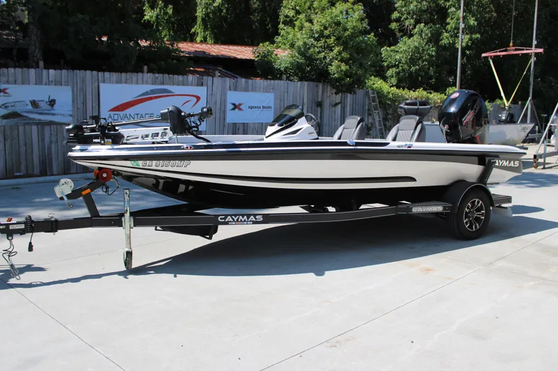 Slide: The Image of 2022 Caymas CX 18 SS boat on trailer, parked outdoors, surrounded by trees and fencing. - 3