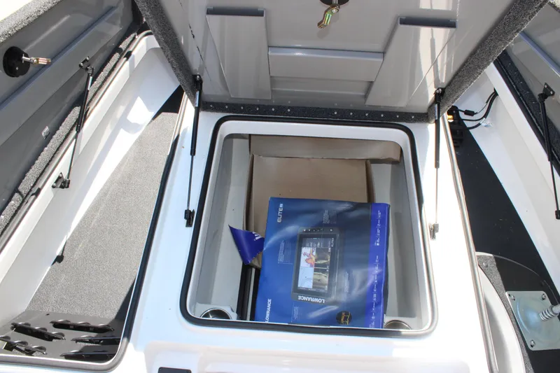 Slide: The Image of Open storage compartment in 2022 Caymas CX 18 SS boat, featuring a Lowrance device box. - 8
