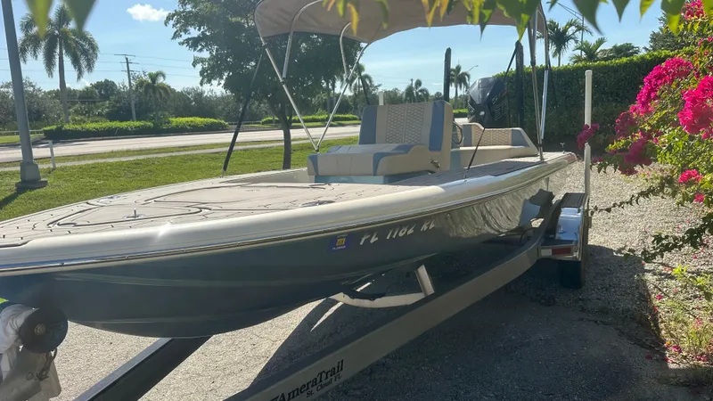 Slide: The Image of 2018 Outlaw 300R boat on trailer, surrounded by vibrant flowers and greenery. - 14