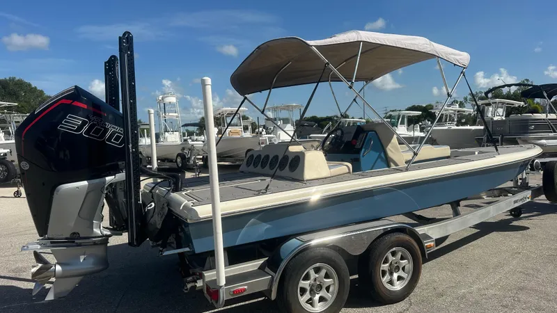 Slide: The Image of 2018 Outlaw 300R boat with canopy on trailer, featuring powerful engine, parked outdoors. - 17