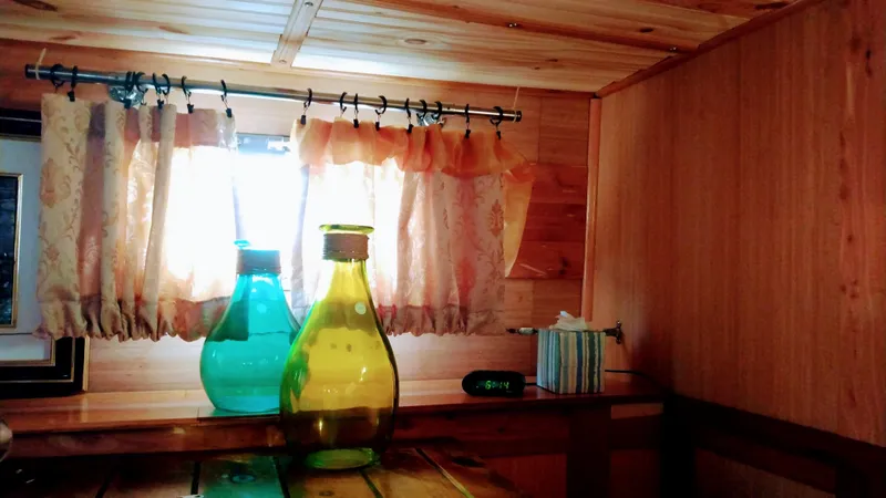 Slide: The Image of Cozy cabin interior of 1989 DeFever 57 POC Motor Yacht with decorative glass bottles. - 14