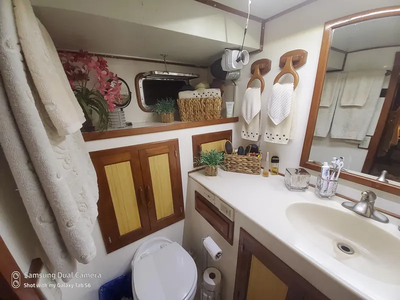 Slide: The Image of Bathroom interior of 1989 DeFever 57 POC Motor Yacht, featuring sink, mirror, and decor. - 15