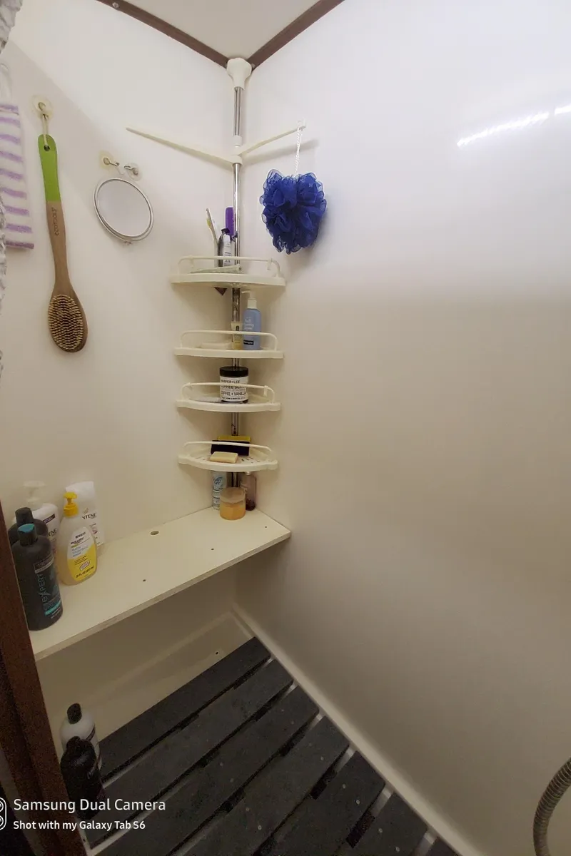 Slide: The Image of Shower area in 1989 DeFever 57 POC Motor Yacht with corner shelves and toiletries. - 17