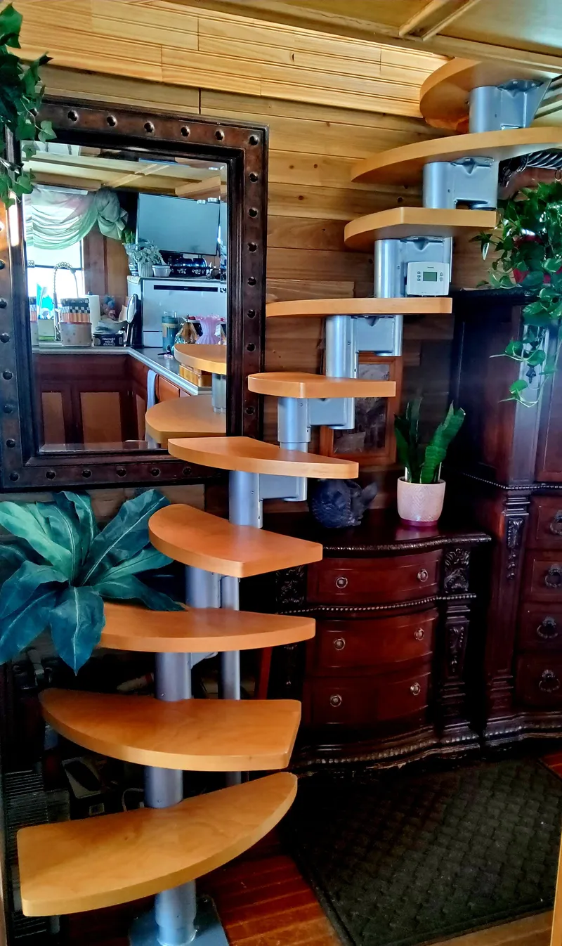 Slide: The Image of Spiral staircase in 1989 DeFever 57 POC Motor Yacht interior with wooden steps and decorative plants. - 23