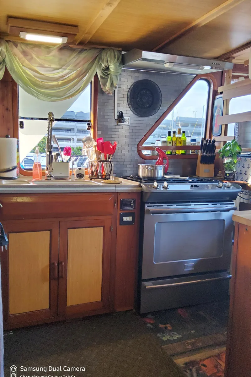 Slide: The Image of 1989 DeFever 57 POC Motor Yacht kitchen with stove, sink, and wooden cabinetry. - 25